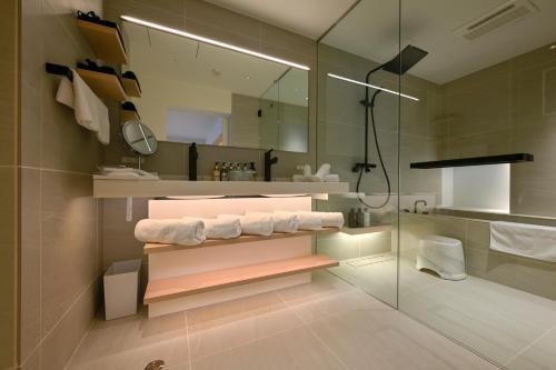 ein Badezimmer mit weißen Handtüchern und einer Dusche in der Unterkunft JINRYU Hotel ISE in Ise