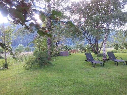 three chairs sitting in the grass in a field at Les Arts Verts in Kruth