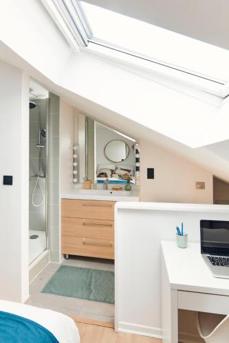 a bathroom with a bed and a desk with a laptop at Charmant T2 - 2min de Lille in Ronchin
