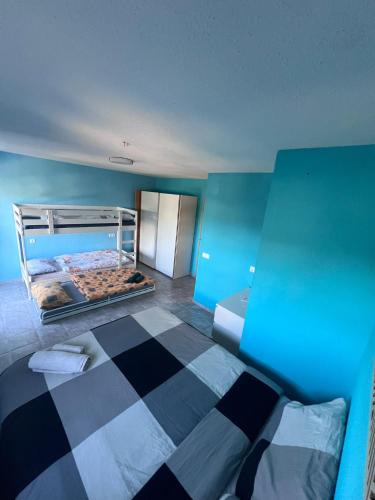 a blue room with a bed with a checkered floor at Casa Latina in Moralet