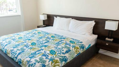 a bedroom with a bed with a blue and white quilt at La Internacional 313 in South Padre Island