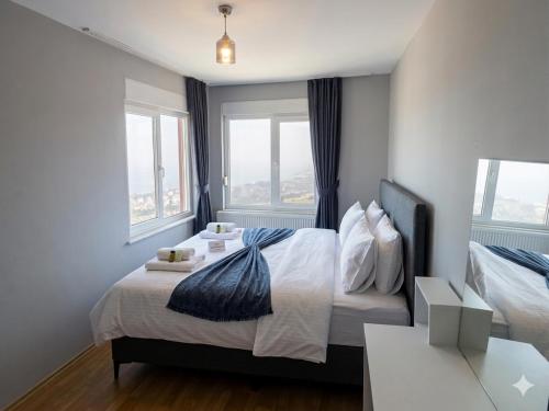 a bedroom with a bed with two windows at Karakum Panorama Suites in Sinop