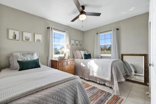 a bedroom with two beds and a ceiling fan at Casa Blanca: Hot-tub, Fire Pit, Hill Country Views in Luckenbach