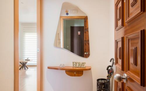 a hallway with a mirror and a small table at BONITO APARTAMENTO in Sitges