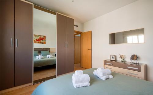 a bedroom with two white towels on a bed at BONITO APARTAMENTO in Sitges