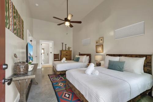 a bedroom with two beds and a ceiling fan at Chic Comfort Just Steps from Main Street! in Fredericksburg