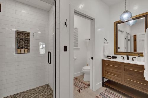 a bathroom with a shower and a toilet and a sink at Chic Comfort Just Steps from Main Street! in Fredericksburg