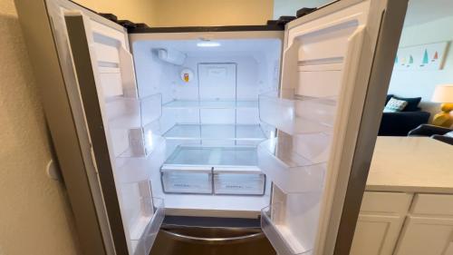 an empty refrigerator with its door open in a room at La Internacional 313 in South Padre Island