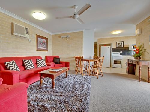 a living room with a red couch and a table at Murray Street Apartments in Rockhampton