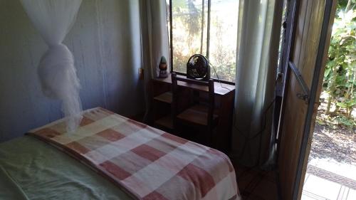 a bedroom with a bed and a door to a window at Árbol de mayo in Guápiles
