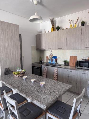 a kitchen with a table with chairs and a counter top at J&J spacious balcony apartment in Preveza