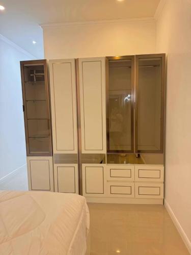 a bedroom with white cabinets and a bed at pp villa phatthalung in Phatthalung