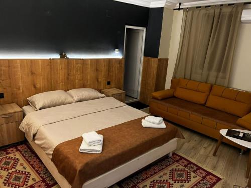 a bedroom with a large bed and a couch at Hotel Lido in Prishtinë