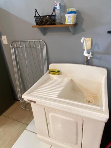 a white sink in a room with a radiator at Casa de Férias Balneário Gaivota in Balneário Gaivotas