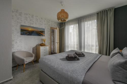 a bedroom with a bed with a chair and a window at Monopol Apartments in Wernigerode