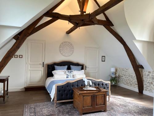 a bedroom with a bed and a wooden table at La Brosse Estate - Chateau de la Brosse in Lureuil