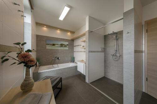 a bathroom with a shower and a vase with flowers at Monopol Apartments in Wernigerode