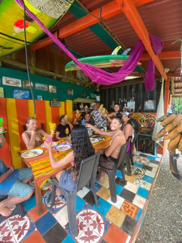 a group of people sitting at a table in a restaurant at Paraisurf colombia in Nuquí