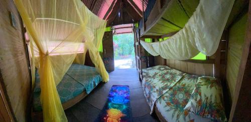 an inside view of a room with beds and curtains at Paraisurf colombia in Nuquí