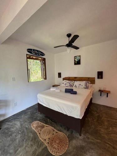 a bedroom with a bed with a ceiling fan at CASA NANDOS Studio quintal da mata !!! in Itacaré
