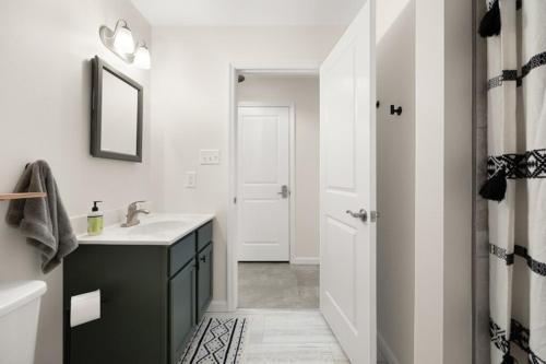 a white bathroom with a sink and a mirror at Maine Woods Retreat in Ellsworth