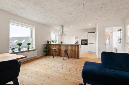 a living room with a couch and a kitchen at 3 værelses lejlighed in Herning