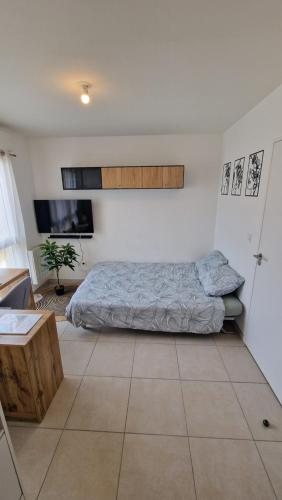 a bedroom with a bed and a tiled floor at Studio avec parking privé - Proche écoles & hôpital - Valence in Valence