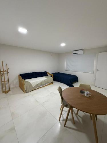 a living room with a bed and a table at Coloft - Hospedagem e Coworking in Anápolis