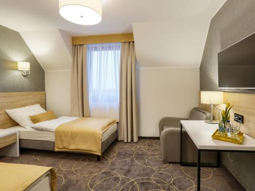 een hotelkamer met een bed en een bank bij Hotel Antek in Zlinice