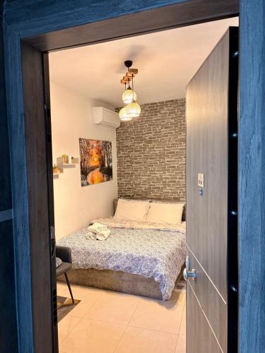 a bedroom with a bed and a brick wall at Central & Riverfront Room 1 in Edessa