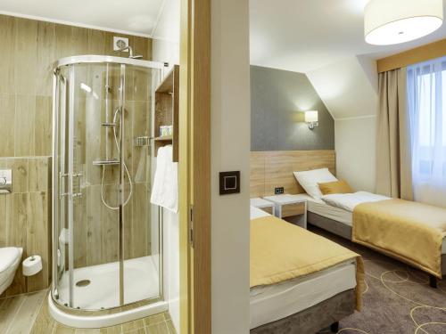 una habitación de hotel con ducha y un dormitorio en Hotel Antek en Zlinice