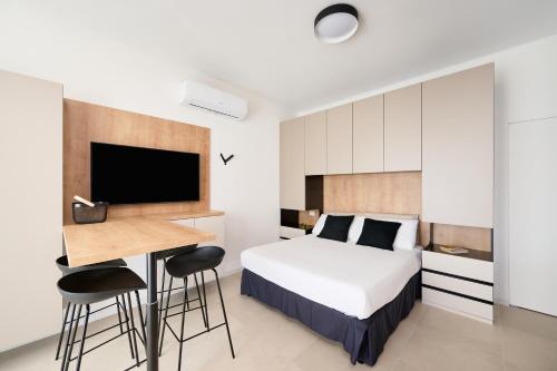a bedroom with a bed and a desk and a tv at Pilone del Monaco - Pool & Free Parking in Vieste