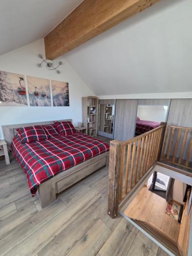 a bedroom with a large bed with a red blanket at Maisonnette cosy montagne in La Garde