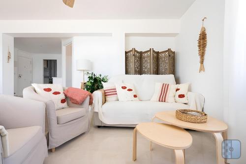 a living room with two white couches and a table at El Acuario - Primera línea y todas las ventanas dan al mar in Cullera