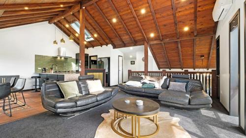 a living room with two couches and a table at Mountain View Chalet in Wanaka