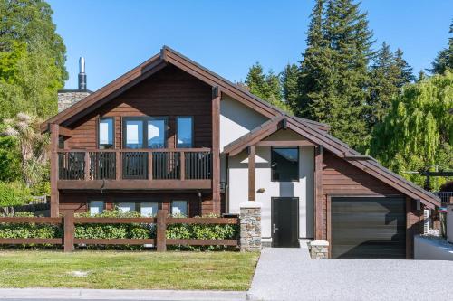 a wooden house with a fence and a garage at Mountain View Chalet in Wanaka