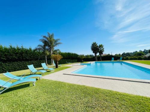 a swimming pool with two lounge chairs next to it at Villa Vieira in Alvarães