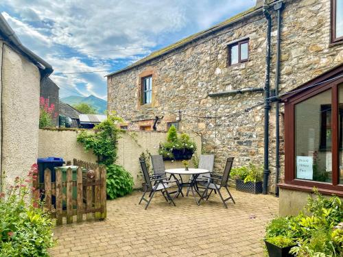a patio with a table and chairs in front of a building at Brook House 2 - Uk31043 in Bassenthwaite