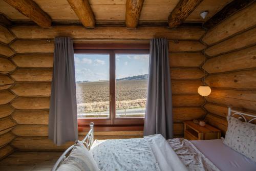a bedroom with a window in a log cabin at Zrub Kriváň Chalet with Mountain View in Závažná Poruba