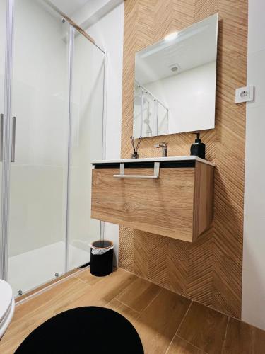 a bathroom with a sink and a mirror at House Caparica in Costa da Caparica