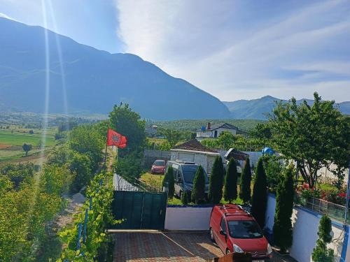 a red car parked in a parking lot next to a fence at Camping SuperPanorama in Kukës
