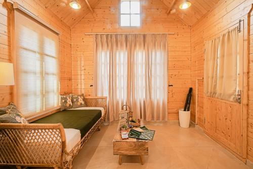 a bedroom with a bed and a window and a table at Kahani Cottages Palampur in Paror