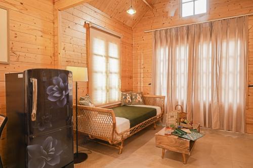 a bedroom with a bed and a refrigerator in a room at Kahani Cottages Palampur in Paror