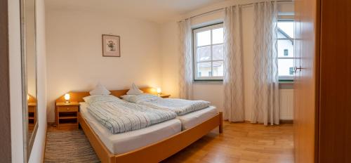 a bedroom with a bed with two lamps on it at Appartementhof Stadler in Pocking