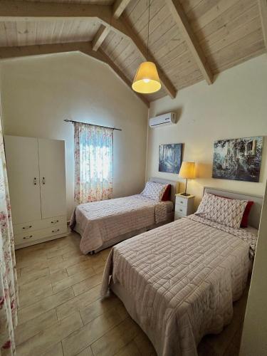 a bedroom with two beds and a ceiling at Villa Cottage Kantrillies in Kefallonia