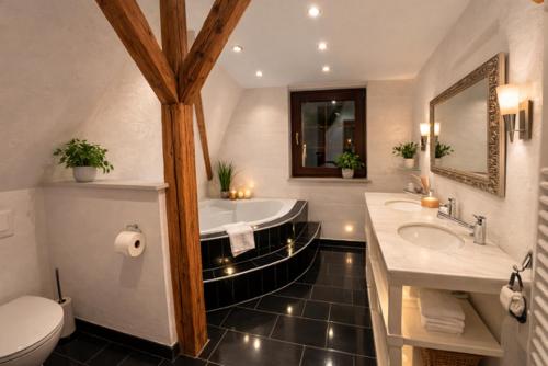 a bathroom with a tub and a toilet and a sink at Villa Christina in Kamp-Bornhofen