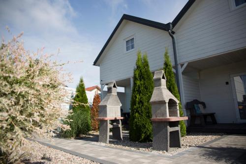 a house with two stone bird baths in the yard at Domki Scandinavia in Rowy