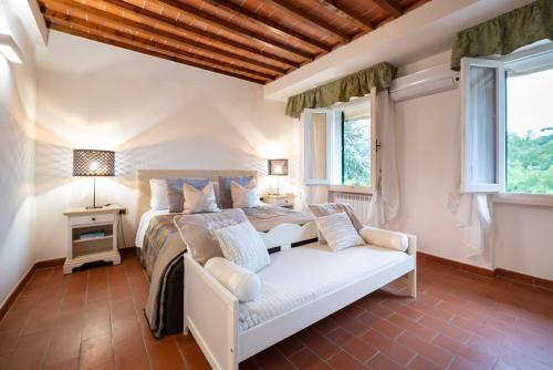 a bedroom with a bed and a couch and windows at Cascina De' Fagiolari in Lastra a Signa