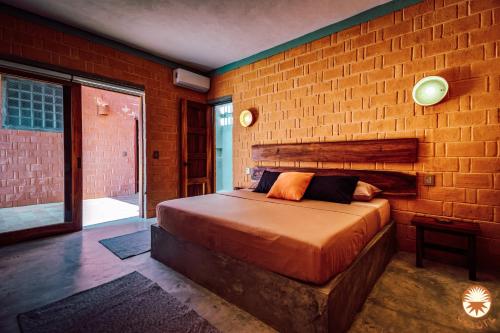 a bedroom with a large bed in a brick wall at Coyote, 7BR Ocean View Villa, 2 Pools, Zipolite in Puerto Ángel