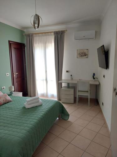 a bedroom with a green bed and a desk at Sikelia in Santa Elisabetta